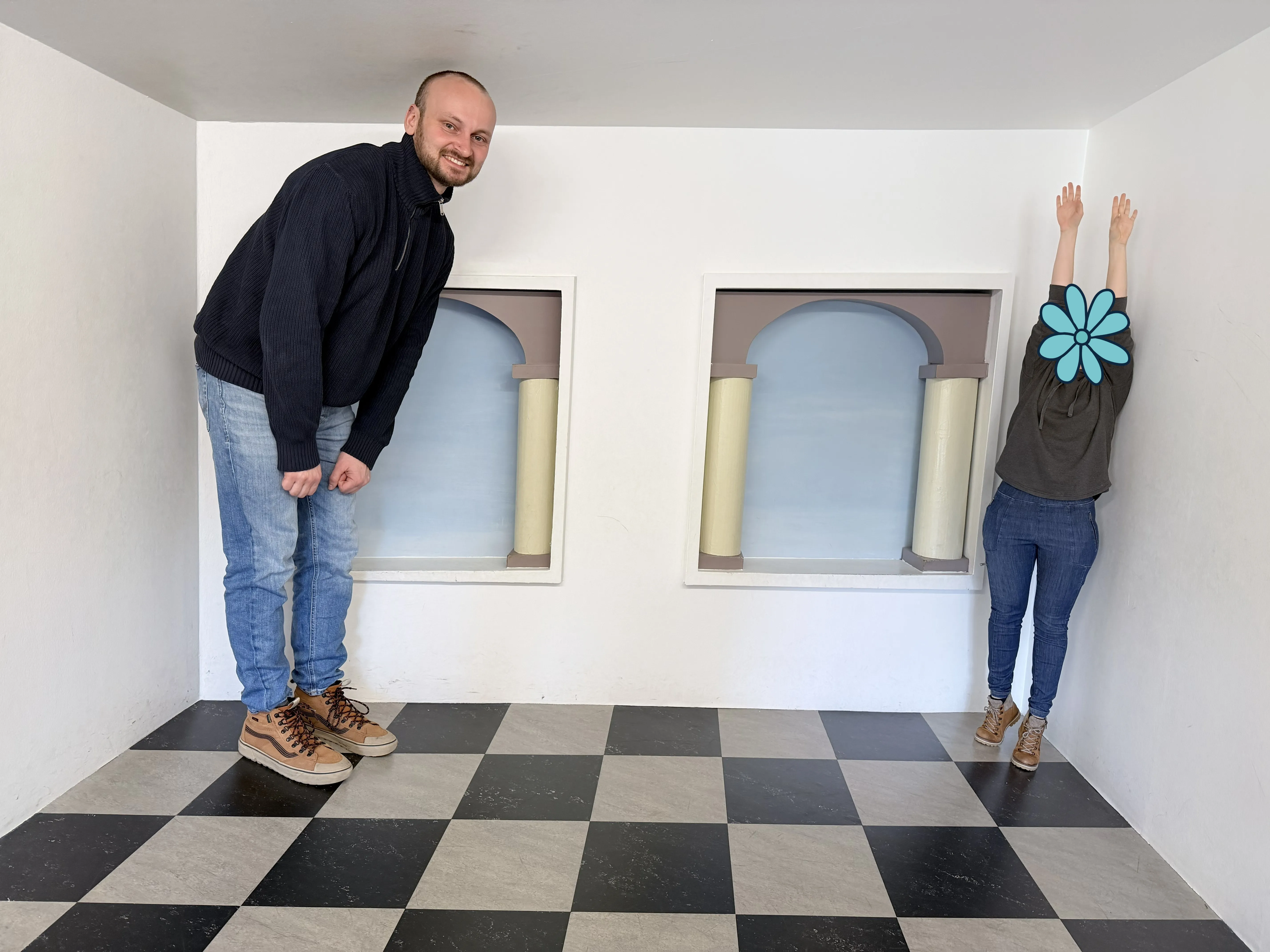 Thanks to the other visitor taking this picture of us when the stationary camera was broken. Unfortunately I was too awkward to also think of a cool pose. Me standing in an optical illusion chamber next to a seemingly much smaller cute blue flower